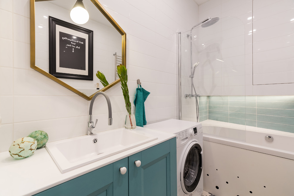 This is an example of a small master bathroom in Saint Petersburg with turquoise cabinets, a shower/bathtub combo, white tile, a drop-in sink, solid surface benchtops, recessed-panel cabinets, an alcove tub, porcelain tile and white benchtops.