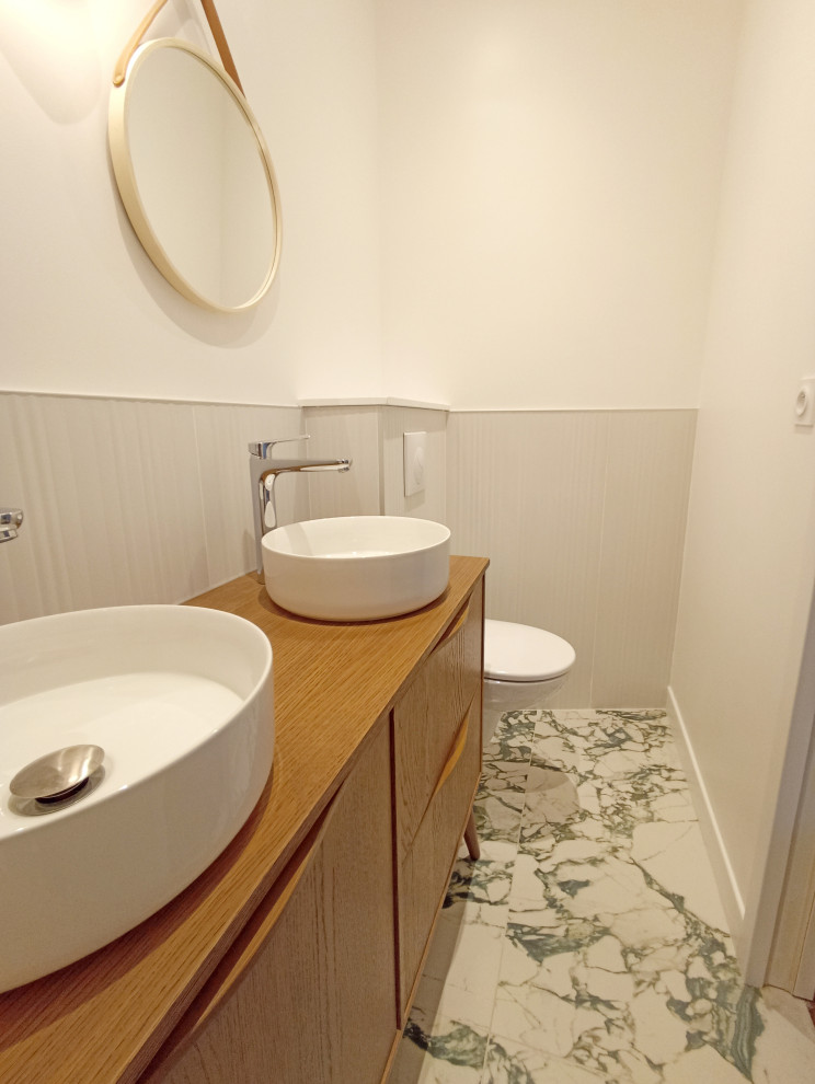 На фото: маленькая ванная комната в современном стиле с белыми фасадами, душем без бортиков, инсталляцией, белой плиткой, керамической плиткой, белыми стенами, мраморным полом, душевой кабиной, накладной раковиной, столешницей из дерева, зеленым полом, душем с раздвижными дверями, тумбой под две раковины и напольной тумбой для на участке и в саду