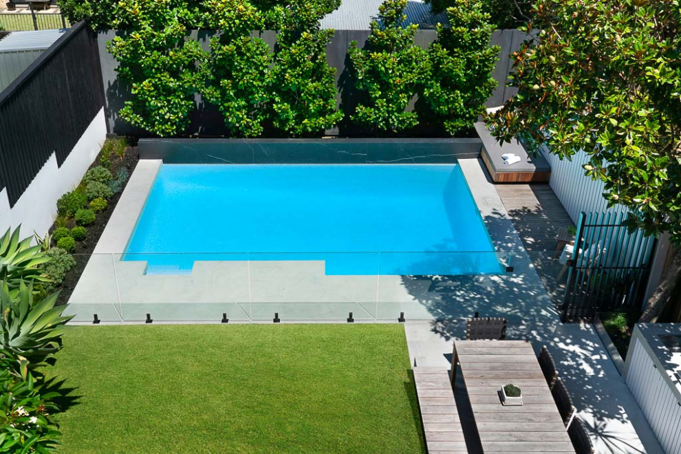 Idéer för en stor modern pool insynsskydd och på baksidan av huset, med marksten i betong