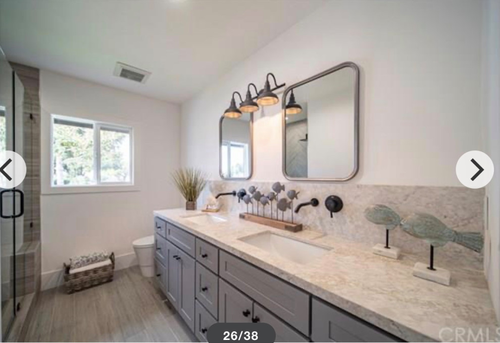 Photo of a mid-sized country kids bathroom in Los Angeles with shaker cabinets, grey cabinets, an alcove shower, a one-piece toilet, gray tile, wood-look tile, white walls, porcelain floors, an undermount sink, engineered quartz benchtops, grey floor, a hinged shower door, grey benchtops, a shower seat, a double vanity and a built-in vanity.