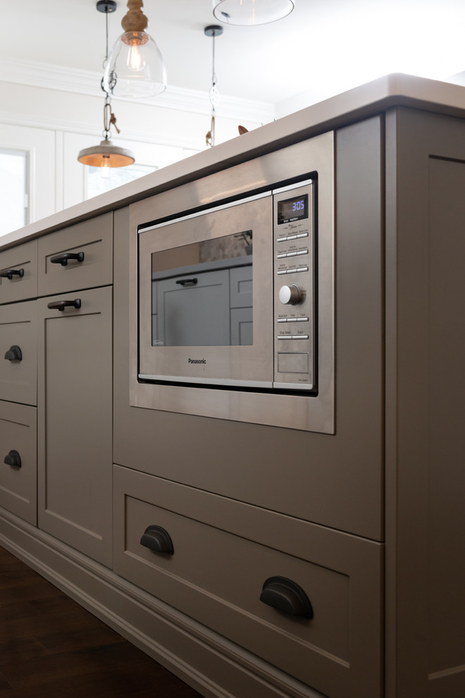 Home design - transitional dark wood floor and brown floor home design idea with white cabinets, quartz countertops, paneled appliances, an island and white countertops