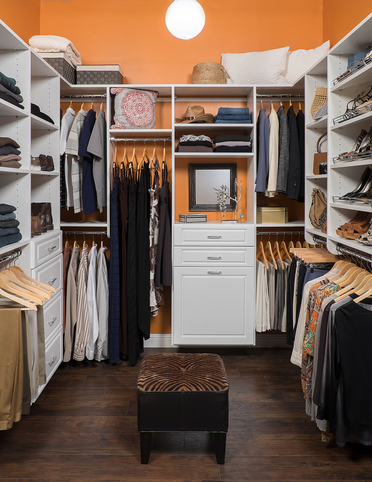Mid-sized traditional gender-neutral walk-in wardrobe in Denver with raised-panel cabinets, white cabinets and medium hardwood floors.