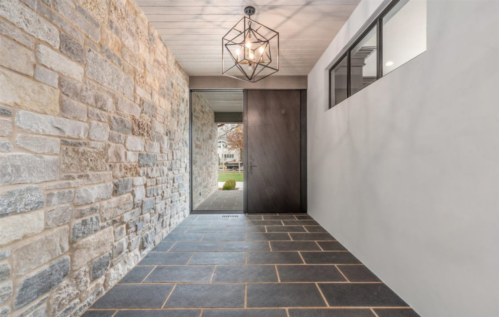 Example of a mid-sized transitional slate floor, gray floor and wood ceiling foyer design in Chicago with white walls and a dark wood front door