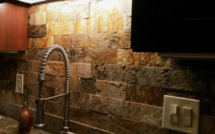 Inspiration for a large rustic l-shaped marble floor, multicolored floor and vaulted ceiling eat-in kitchen remodel in Austin with an undermount sink, raised-panel cabinets, dark wood cabinets, granite countertops, multicolored backsplash, metal backsplash, stainless steel appliances, an island and multicolored countertops