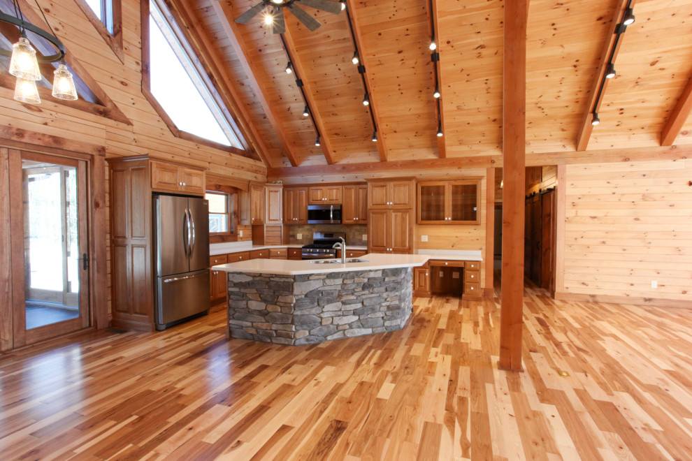 Eat-in kitchen - rustic u-shaped light wood floor, yellow floor and wood ceiling eat-in kitchen idea with a double-bowl sink, raised-panel cabinets, medium tone wood cabinets, wood backsplash, stainless steel appliances, an island and white countertops