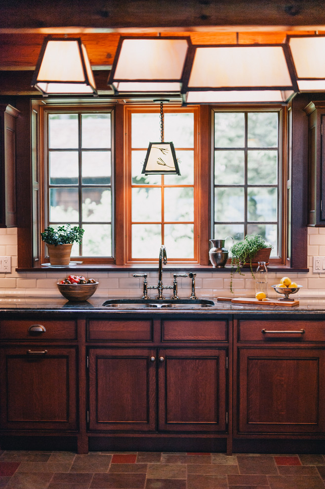Photo of a large country u-shaped eat-in kitchen in Boston with no island, beaded inset cabinets, dark wood cabinets, granite benchtops, white splashback, subway tile splashback, stainless steel appliances, a double-bowl sink and slate floors.