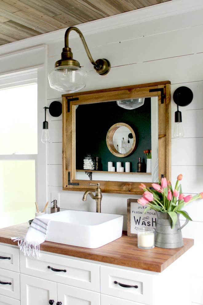 Bathroom - country bathroom idea in Orlando with recessed-panel cabinets, white cabinets, white walls and a vessel sink