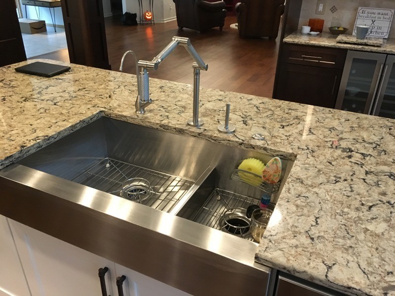 Large transitional u-shaped porcelain tile open concept kitchen photo in Detroit with a farmhouse sink, shaker cabinets, white cabinets, quartz countertops, beige backsplash, stone tile backsplash, stainless steel appliances and an island