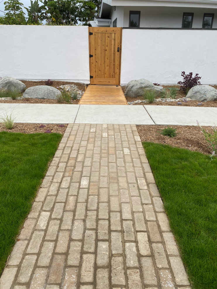 Esempio di un grande giardino xeriscape minimal esposto in pieno sole davanti casa in estate con un ingresso o sentiero e pavimentazioni in mattoni