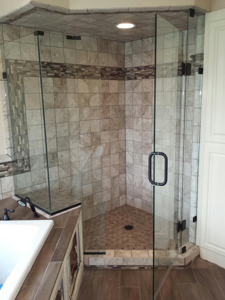 Inspiration for a mid-sized traditional master bathroom in Minneapolis with a drop-in tub, an alcove shower, beige tile, brown tile, ceramic tile, beige walls, porcelain floors, brown floor and a hinged shower door.