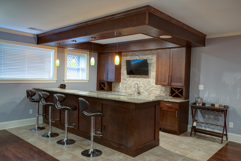 This is an example of a mid-sized contemporary galley seated home bar in Atlanta with shaker cabinets, dark wood cabinets, granite benchtops, beige splashback, stone tile splashback and ceramic floors.