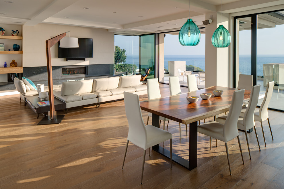 This is an example of a large contemporary open plan dining in San Diego with white walls, brown floor and medium hardwood floors.