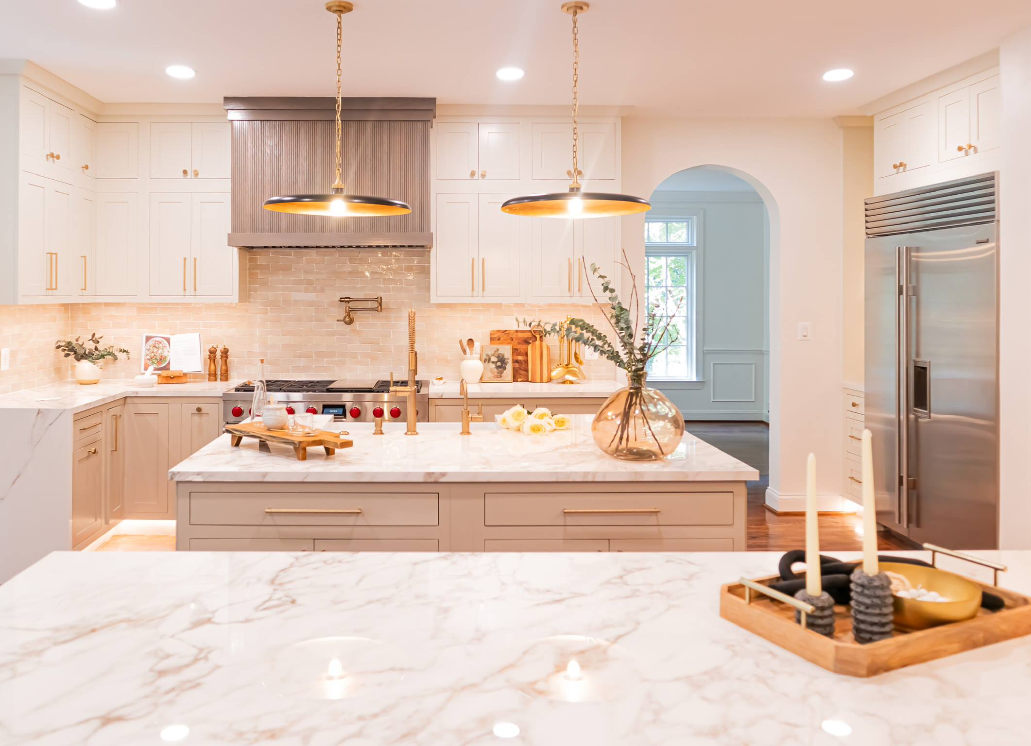 A timeless kitchen, curated with neutral tones, textures, and depth. We are completely in love with every detail from the fluted hood and peninsula, fluted fire clay sink, lux gold knurled hardware, a