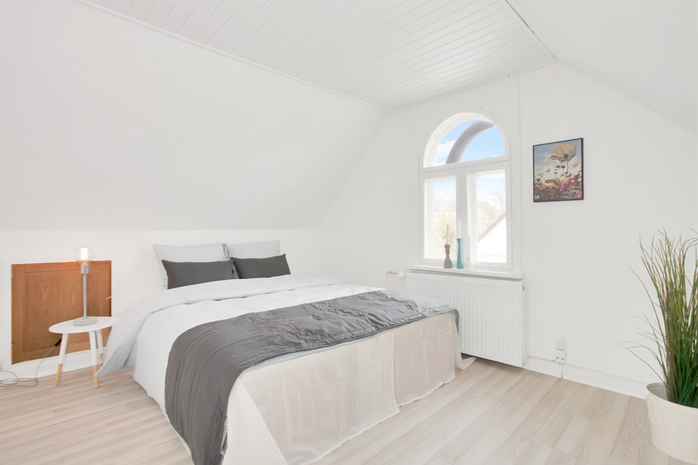 Mid-sized scandinavian master bedroom in Copenhagen with white walls, light hardwood floors and no fireplace.