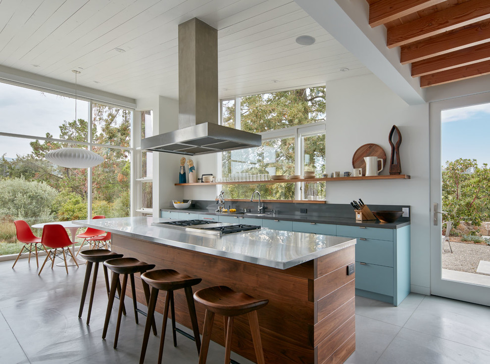 Inspiration for a contemporary galley open plan kitchen in San Francisco with an undermount sink, flat-panel cabinets, blue cabinets, with island, stainless steel benchtops, grey splashback, stone slab splashback, stainless steel appliances and concrete floors.
