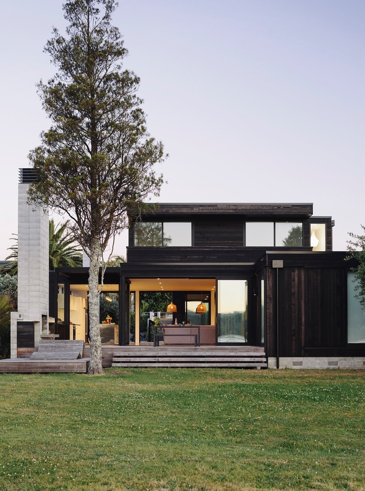 Mid-sized contemporary two-storey exterior in Auckland with wood siding.