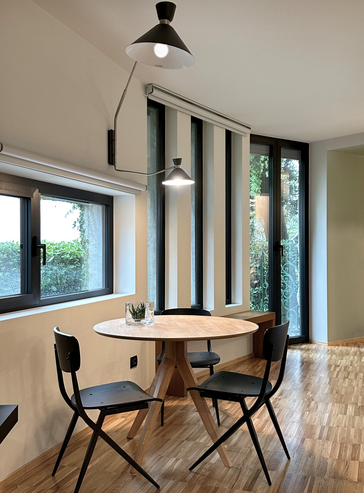 Idée de décoration pour un petit salon design ouvert avec un bar de salon, un mur vert, un sol en bois brun, un téléviseur fixé au mur et boiseries.