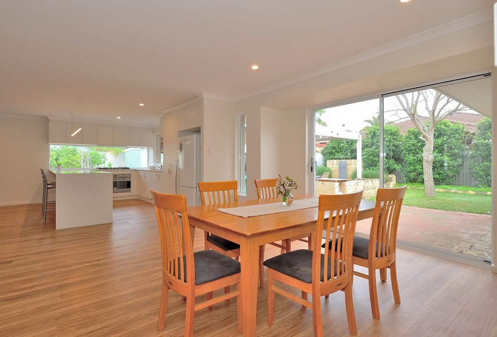 Design ideas for a mid-sized modern open plan dining in Perth with white walls, medium hardwood floors and brown floor.