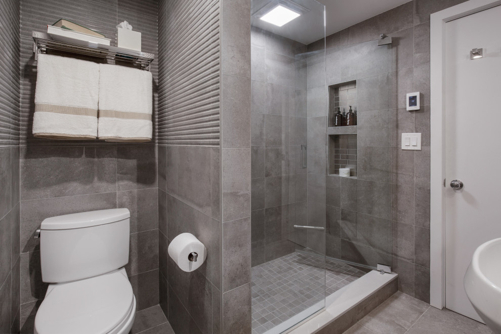 Design ideas for a mid-sized contemporary bathroom in Boston with an alcove shower, a two-piece toilet, gray tile, ceramic tile, ceramic floors, a pedestal sink, grey floor, a hinged shower door, a niche and a single vanity.