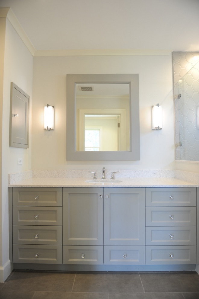 This is an example of a transitional bathroom in Dallas with recessed-panel cabinets, grey cabinets, gray tile, ceramic tile, white benchtops, a corner shower, white walls and grey floor.