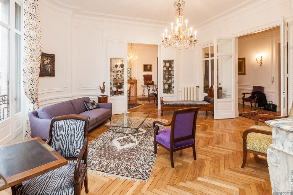 This is an example of a large traditional open concept family room in Toulouse with white walls, light hardwood floors, a standard fireplace, a wood fireplace surround and no tv.