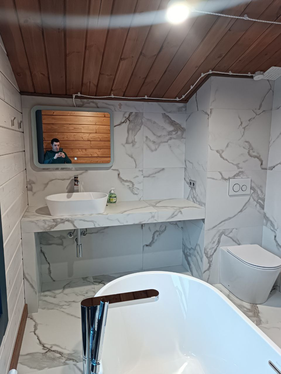 Современная ванная в доме с мансардой: керамогранит и дерево