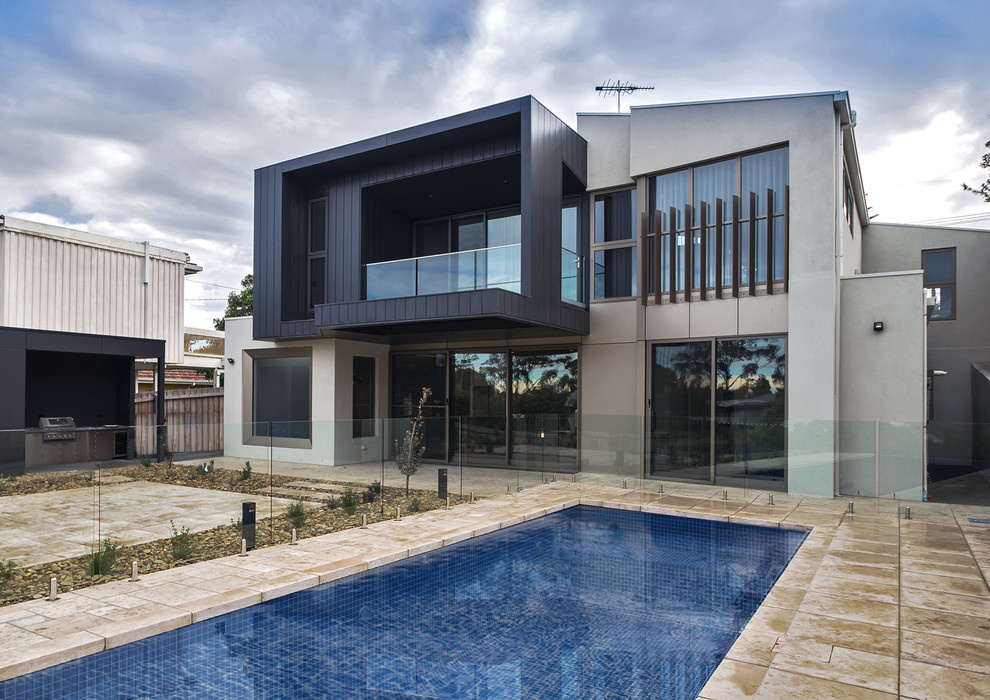 Inspiration for a large modern two-storey grey house exterior in Melbourne with metal siding, a flat roof and a metal roof.