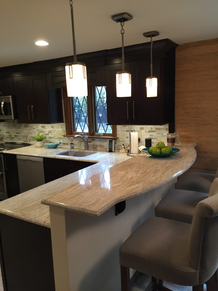 Example of a transitional ceramic tile kitchen design with a single-bowl sink, dark wood cabinets, multicolored backsplash, mosaic tile backsplash, stainless steel appliances and an island