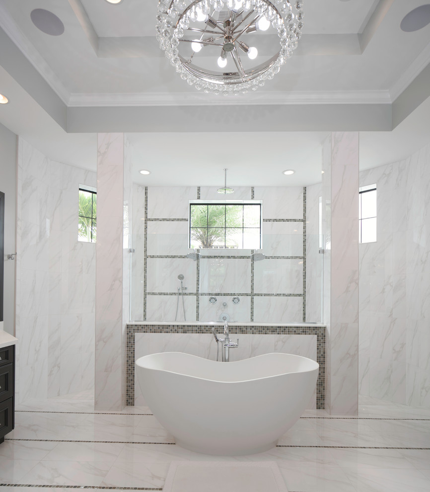 Large transitional master white tile and marble tile marble floor and white floor freestanding bathtub photo in Miami with dark wood cabinets and white walls