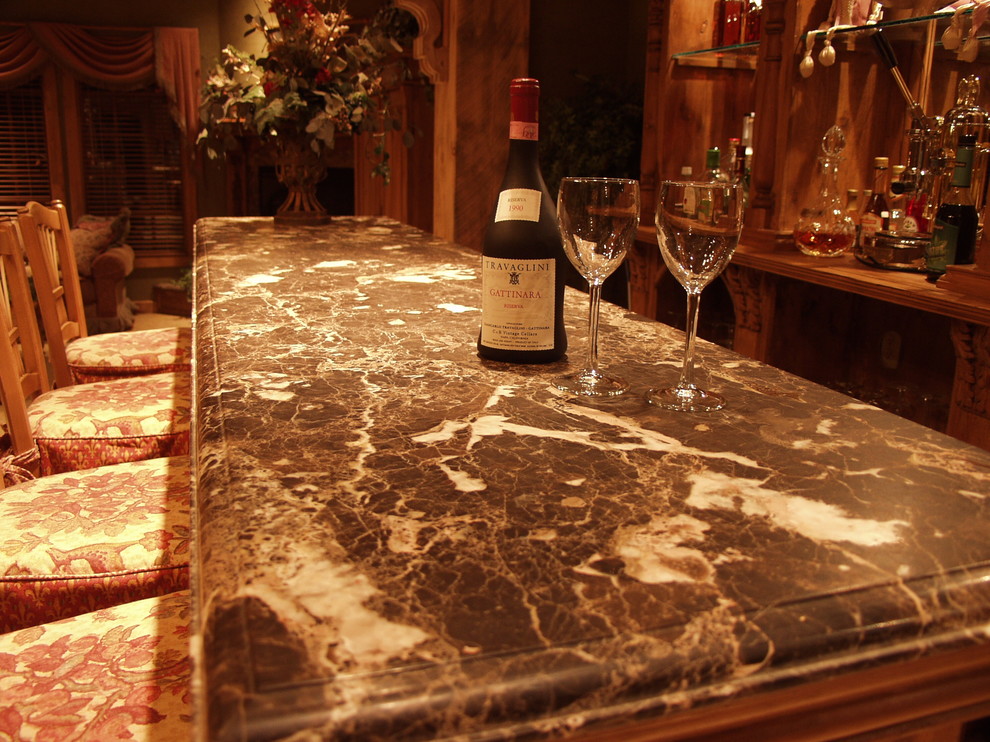 Example of a large mountain style l-shaped medium tone wood floor and brown floor open concept kitchen design with an undermount sink, white cabinets, granite countertops, brown backsplash, stone tile backsplash, stainless steel appliances and an island