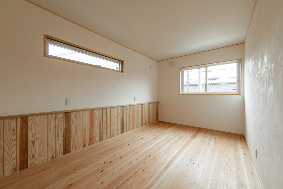 Réalisation d'une chambre parentale avec un mur blanc, un sol en bois brun, un sol marron et différents habillages de murs.