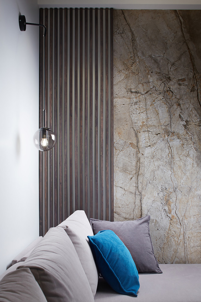 Cette image montre un salon nordique avec un mur gris et un sol en bois brun.