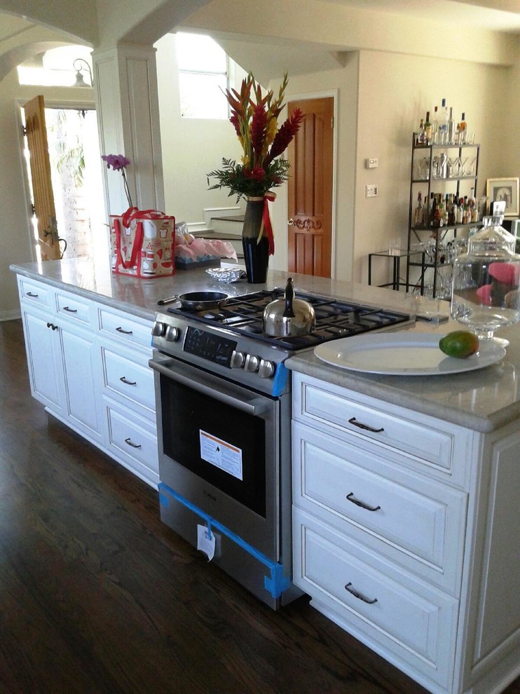 Photo of a small country galley kitchen in Los Angeles with raised-panel cabinets, white cabinets and with island.