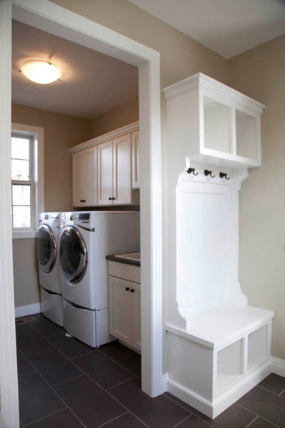 This is an example of a mid-sized transitional single-wall dedicated laundry room in Denver with a drop-in sink, shaker cabinets, white cabinets, laminate benchtops, grey walls, porcelain floors and a side-by-side washer and dryer.