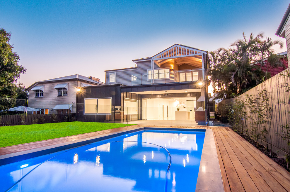 Inspiration for a large traditional backyard rectangular lap pool in Brisbane with decking.