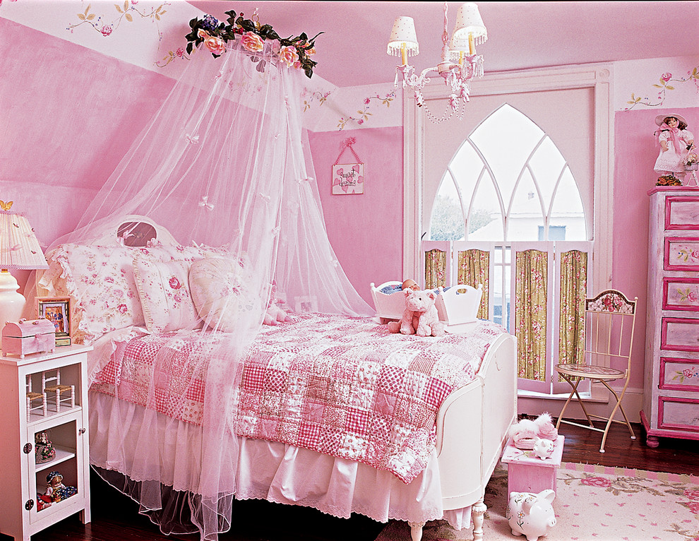 This is an example of a small traditional kids' room for girls in Charleston with pink walls and dark hardwood floors.