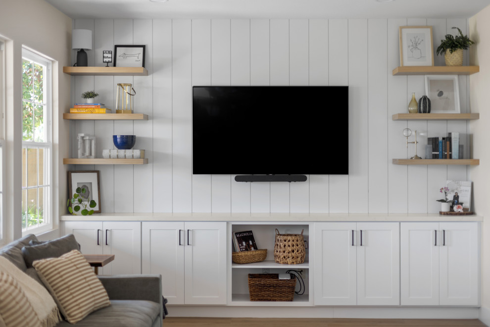 Ejemplo de sala de estar moderna de tamaño medio sin chimenea con paredes blancas, suelo de madera en tonos medios, televisor colgado en la pared, suelo marrón y machihembrado