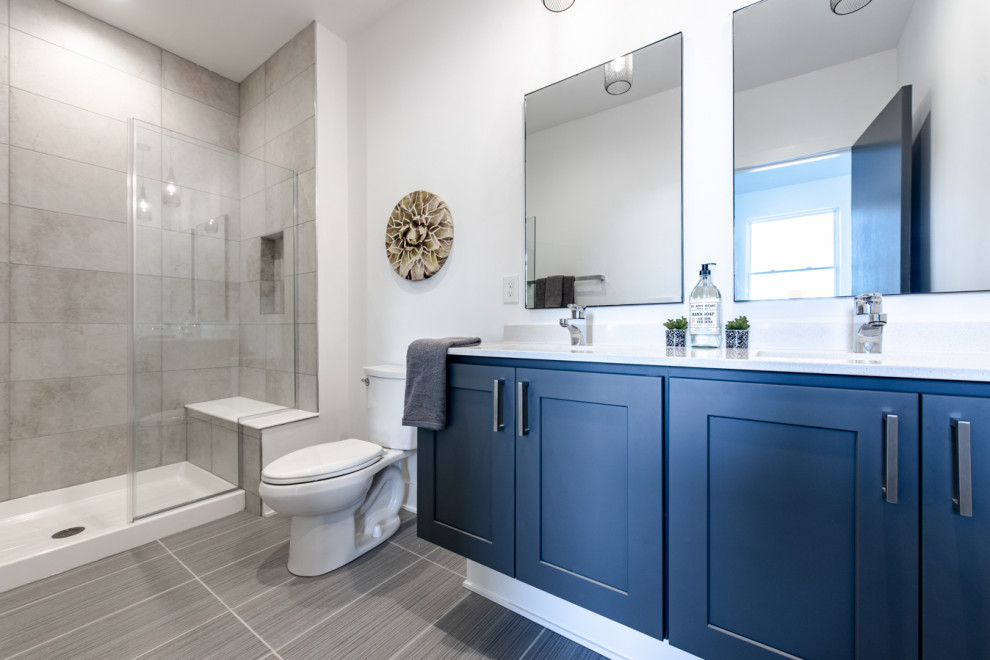 Inspiration for a large transitional master bathroom in Columbus with shaker cabinets, blue cabinets, an alcove shower, a two-piece toilet, gray tile, white walls, an undermount sink, grey floor and white benchtops.