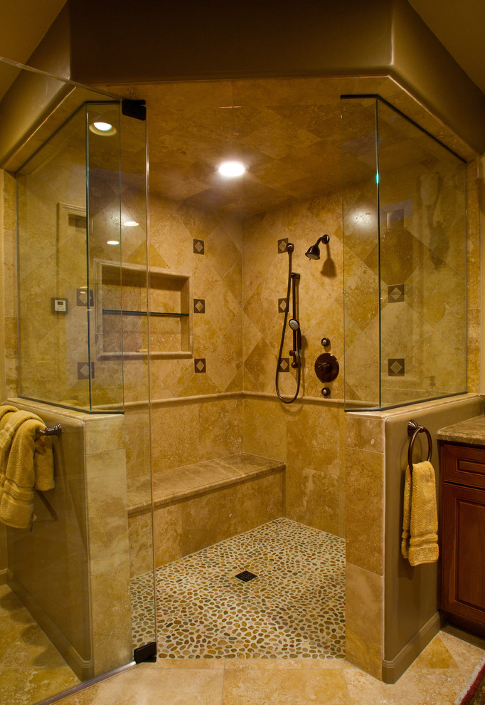 Inspiration for a traditional master bathroom in Phoenix with raised-panel cabinets, medium wood cabinets, granite benchtops, a corner shower, beige tile, stone tile, yellow walls and pebble tile floors.