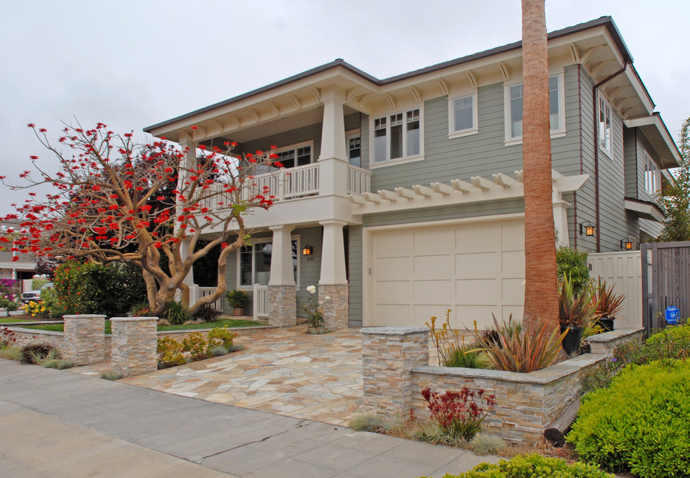 This is an example of a large arts and crafts two-storey grey house exterior in San Diego with concrete fiberboard siding and a hip roof.