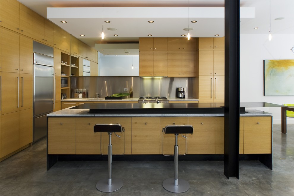 Contemporary kitchen in San Francisco with flat-panel cabinets, metallic splashback, metal splashback, stainless steel appliances and light wood cabinets.