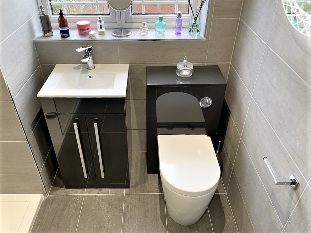 Photo of a mid-sized modern kids bathroom in Other with flat-panel cabinets, grey cabinets, an open shower, a one-piece toilet, gray tile, porcelain tile, porcelain floors, a drop-in sink, grey floor, a niche, a single vanity and a freestanding vanity.