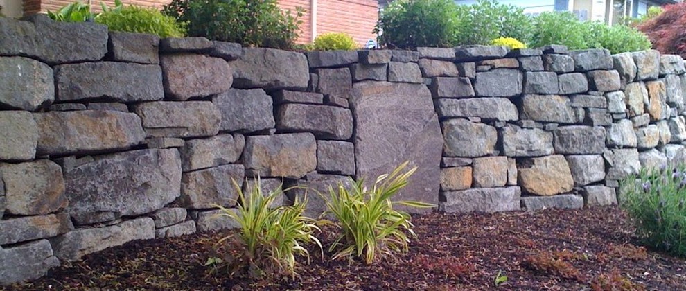 Inspiration for a small traditional backyard full sun garden for spring in Portland with a retaining wall and brick pavers.
