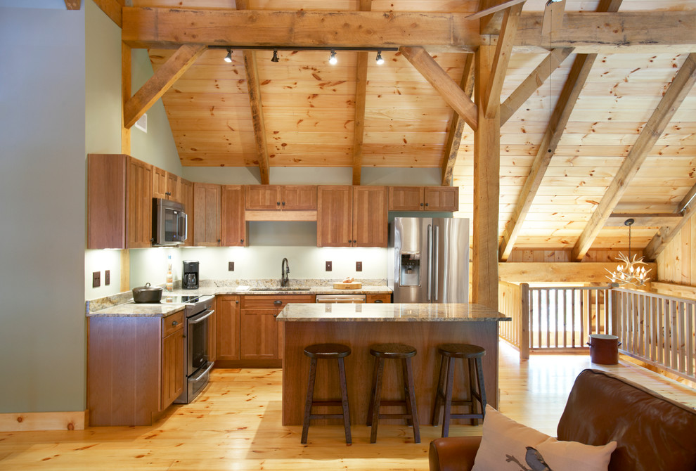 Inspiration for a mid-sized rustic l-shaped light wood floor eat-in kitchen remodel with a double-bowl sink, recessed-panel cabinets, light wood cabinets, green backsplash, stainless steel appliances and an island