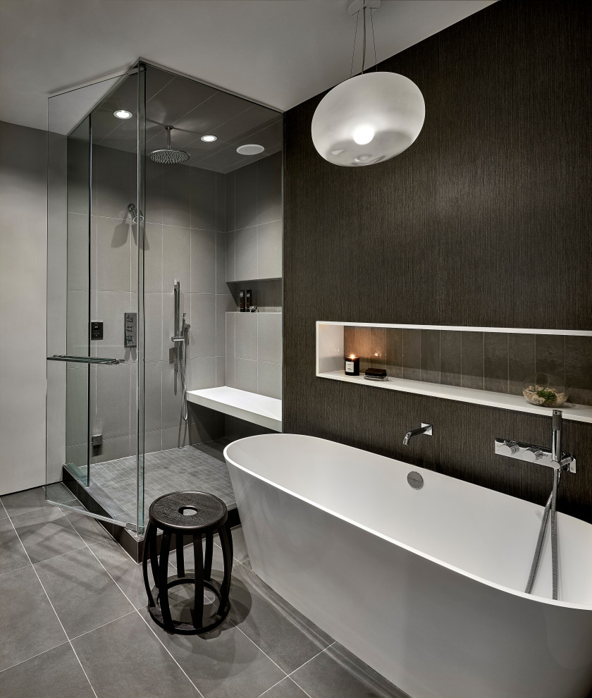 This is an example of a contemporary master bathroom in Chicago with a freestanding tub, a corner shower, gray tile, grey floor, a hinged shower door and a shower seat.