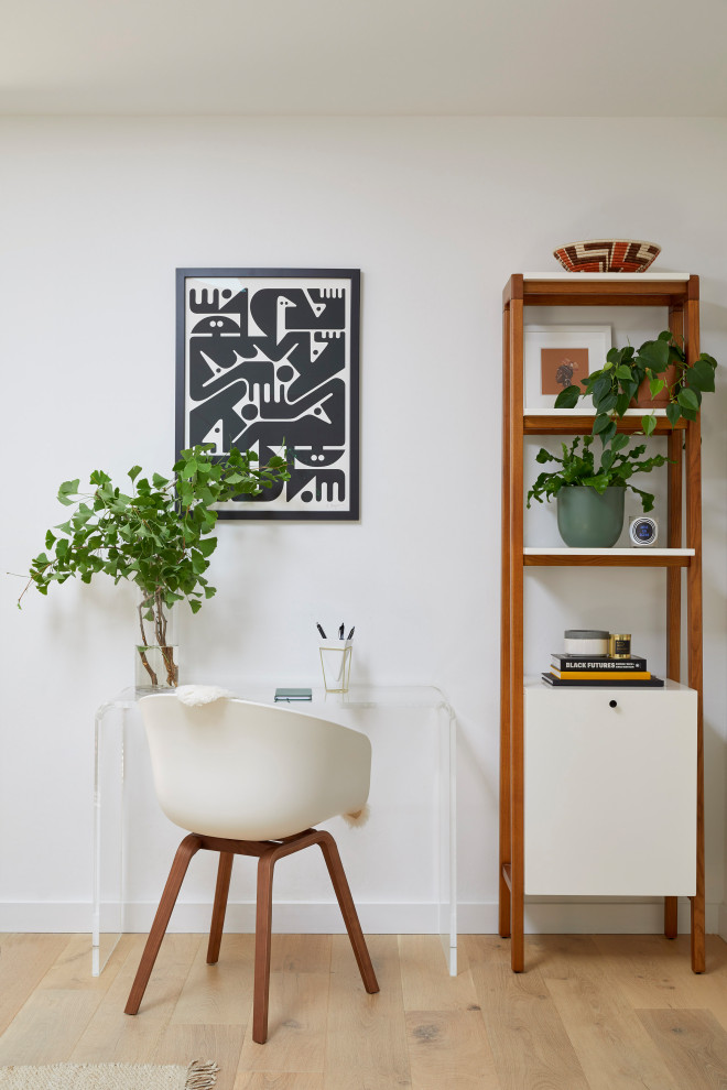 Immagine di un piccolo studio moderno con pareti bianche, parquet chiaro e scrivania autoportante
