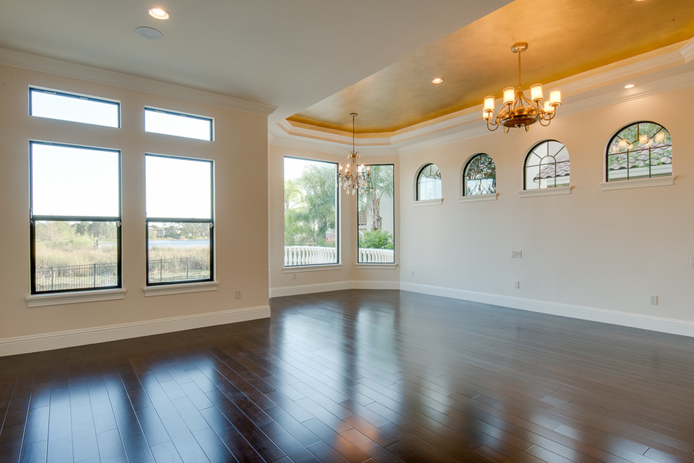Inspiration for an expansive mediterranean master bedroom in Orlando with beige walls and dark hardwood floors.