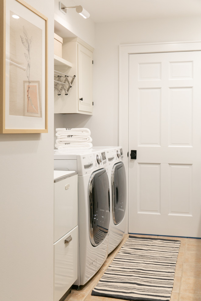 This is an example of a mid-sized transitional galley dedicated laundry room in New York with an utility sink, shaker cabinets, white cabinets, granite benchtops, white splashback, shiplap splashback, white walls, porcelain floors, a side-by-side washer and dryer, beige floor, black benchtop and planked wall panelling.
