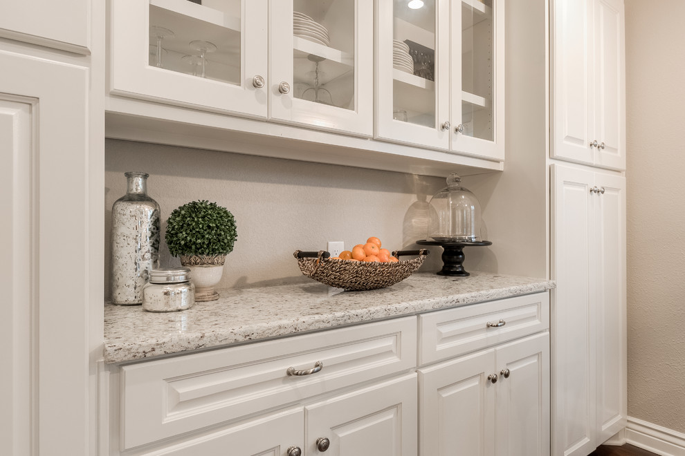 Design ideas for a mid-sized transitional galley separate kitchen in Dallas with an undermount sink, raised-panel cabinets, white cabinets, granite benchtops, white splashback, subway tile splashback, stainless steel appliances, medium hardwood floors and a peninsula.