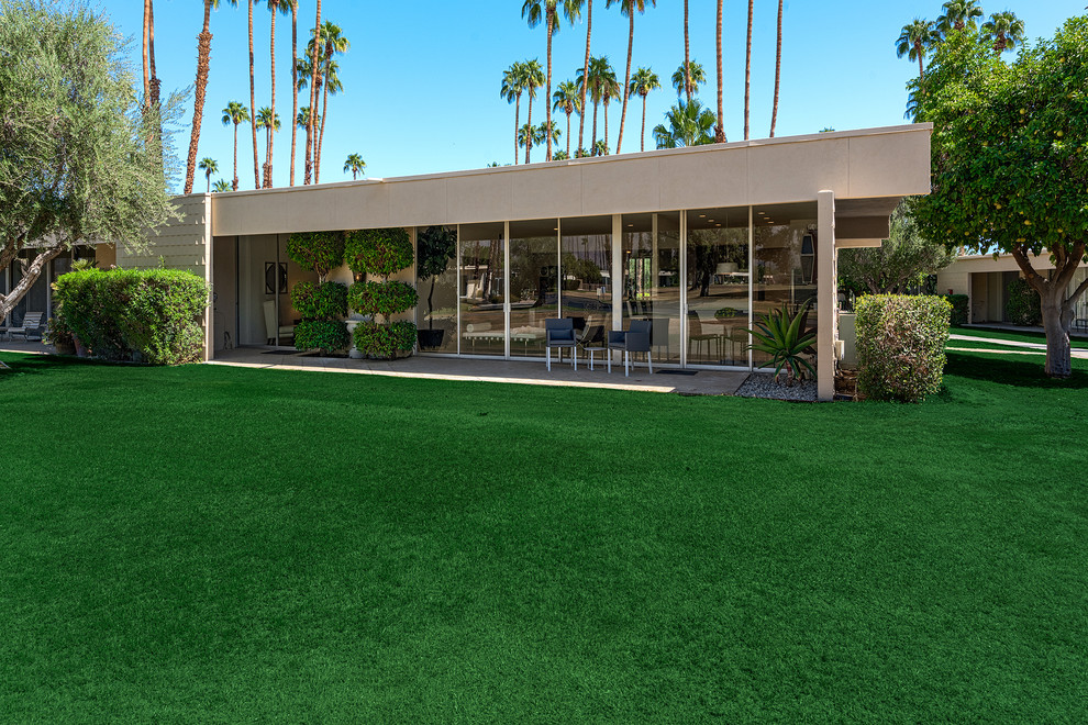 Inspiration for a large midcentury backyard full sun garden in Other with concrete pavers.